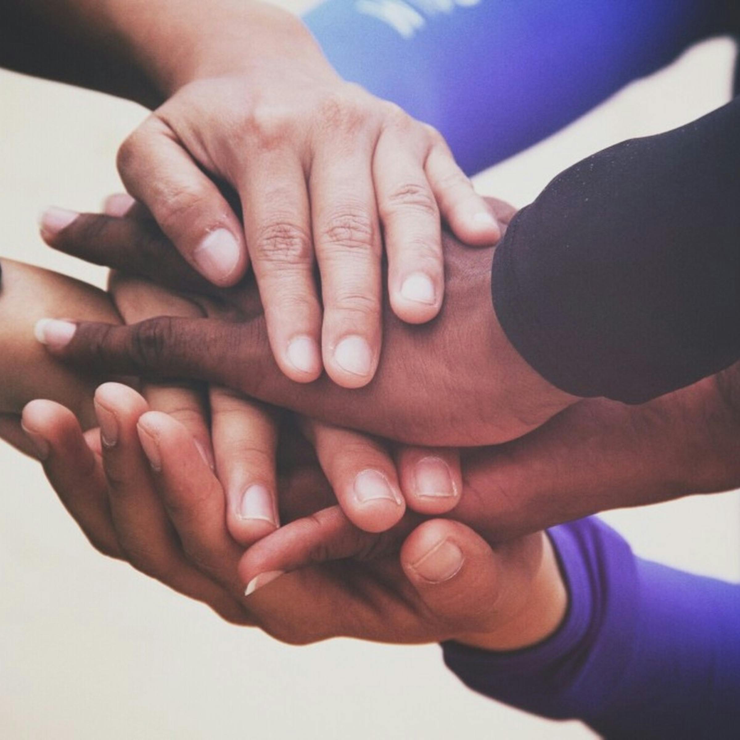 Hands of people from different races placed on top of each other